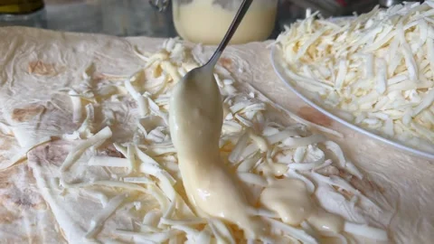Process of making lavash with cheese Cook is adding hard cheese on pita. Process Stock Footage 317222268