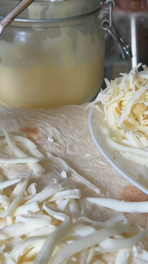 Process of making lavash with cheese Cook is adding hard cheese on pita. Process Stock Footage 323453700