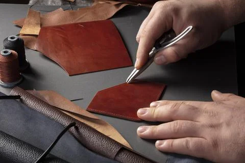 The process of making leather goods. The hands of the master work with a leat Stock Photos