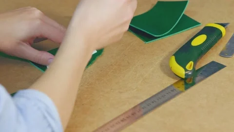 The process of making a leather wallet. green leather. workshop leather Stock Footage 169251771