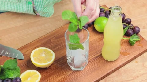 Process of making lemonade drink at the kitchen, glass with ice cubes Stock Footage 158861473