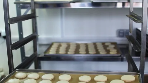 Process of making macaron, Cook puts trays of macarons Stock Footage 70774968