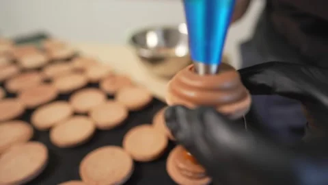 Process Of Making macaroon at home. Shot of hands of female pastry chef holding Stockbeeldmateriaal 153669478