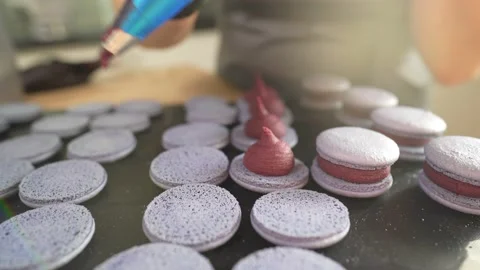 Process Of Making macaroon at home. Shot of hands of female pastry chef holding Stockbeeldmateriaal 153690375
