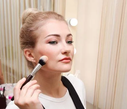 Process of making makeup. Beautiful young woman applying tone to skin. Hand w Foto stock