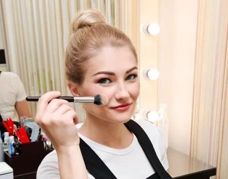 Process of making makeup. Beautiful young woman applying tone to skin. Hand w Stock Photos