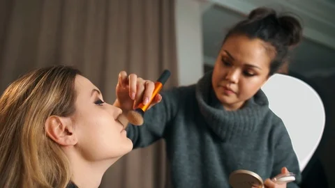 Process of making makeup. Make-up artist working with brush on model face Video stock 119202286