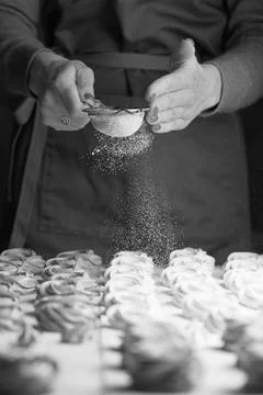 Process of making marshmallow. Close up hands of the chef with metal sieve sp Stock Photos