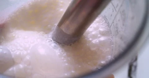 The process of making a milkshake. A mixer froths milk Stock Footage 333578143