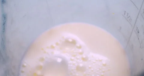 The process of making a milkshake. A mixer froths milk Stock Footage 333579028