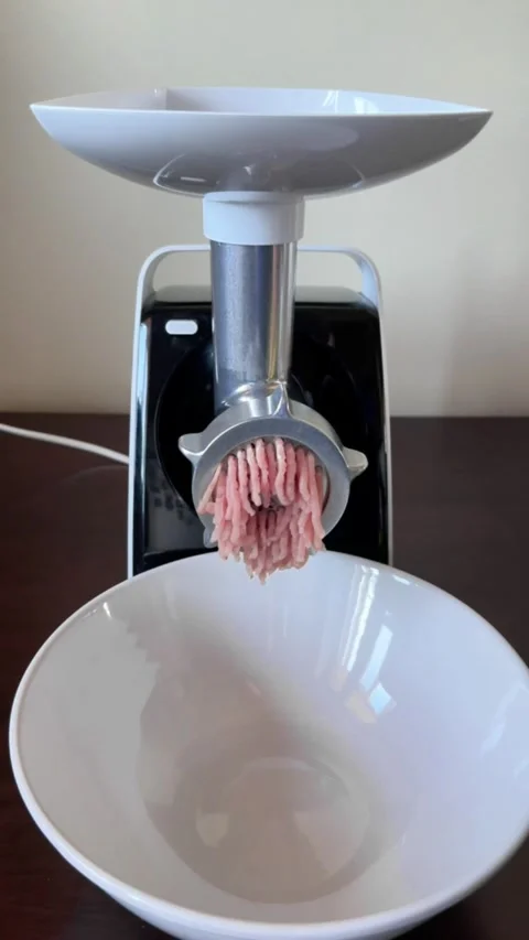 Process of making minced meat with electric meat grinder in home kitchen Stock Footage 318544422