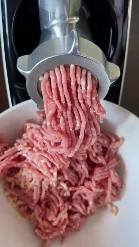 Process of making minced meat with electric meat grinder in home kitchen Stock Footage 318544423