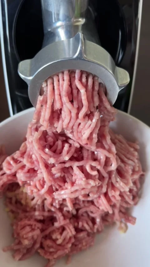 Process of making minced meat with electric meat grinder in home kitchen Stock Footage 318544431