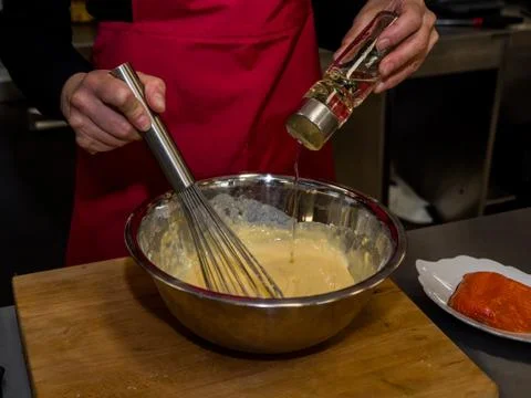 The process of making pancakes. Cook in the kitchen makes the dough Stock-Fotos