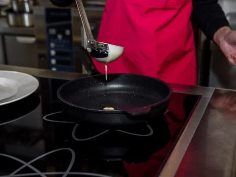 The process of making pancakes. Cook in the kitchen makes the dough Foto stock