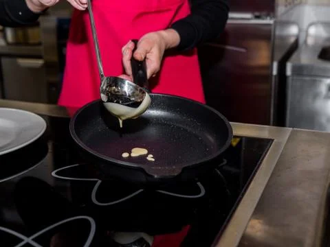 The process of making pancakes. Cook in the kitchen makes the dough Stock-Fotos