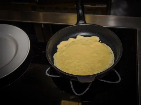 The process of making pancakes. Cook in the kitchen makes the dough Фото
