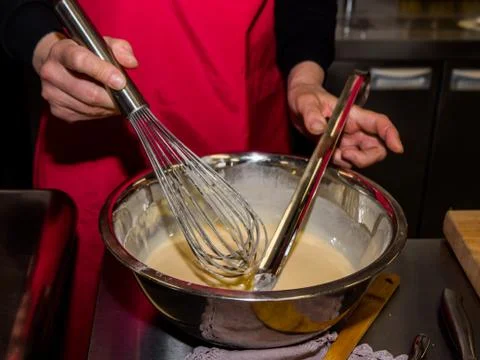 The process of making pancakes. Cook in the kitchen makes the dough Fotos Stock