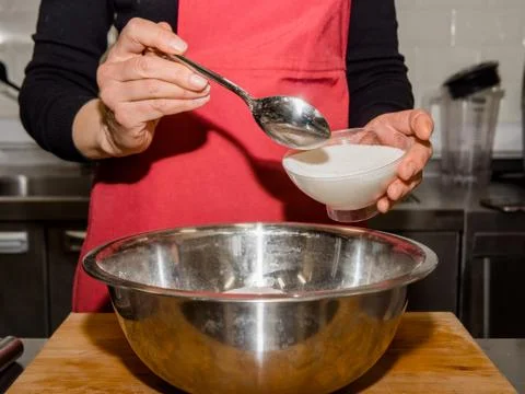 The process of making pancakes. Cook in the kitchen makes the dough. Stock Photos