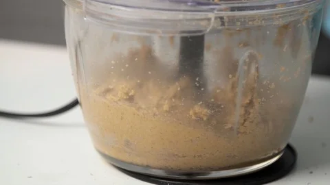 Process of making peanut butter at home - chopping viscous mass Stockbeeldmateriaal 122516677
