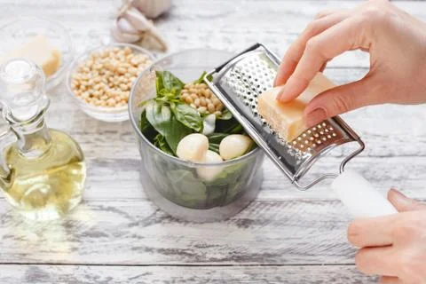 The process of making pesto sauce in a blender from cheese, pine nuts, olive  Stock Photos
