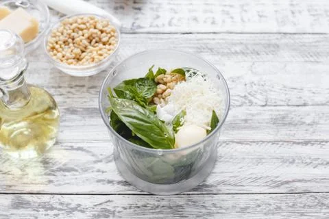 The process of making pesto sauce in a blender from cheese, pine nuts, olive  Stock Photos