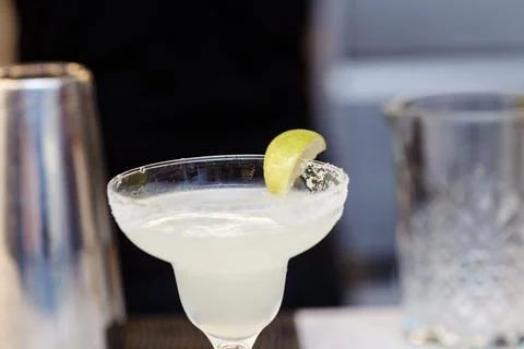 The process of making a pink cocktail with ice on a bar table. Stock Photos