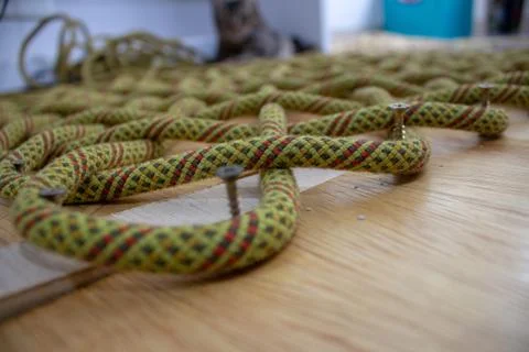 The process of making a rope rug, using an old climbing rope. Using a wooden  Foto stock