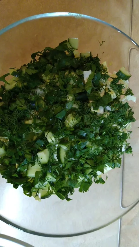 The process of making a salad of cucumbers, parsley and dill close-up Stock Footage 147941028