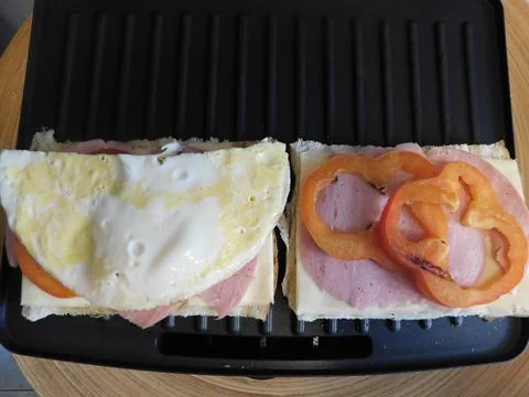 The process of making a sandwich with ham, cheese and egg Foto stock