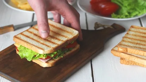 The process of making a sandwich with salad, tomato, ham and cheese. Stock Footage 147848375