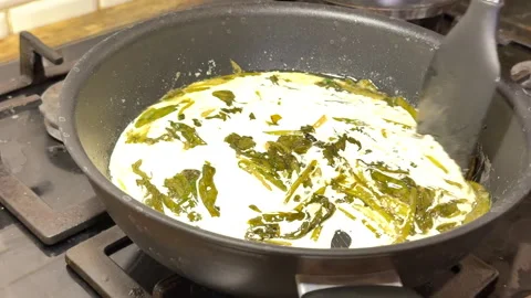 The process of making sorrel sauce with cream, in a skillet on the stove top roa Video stock 301422267