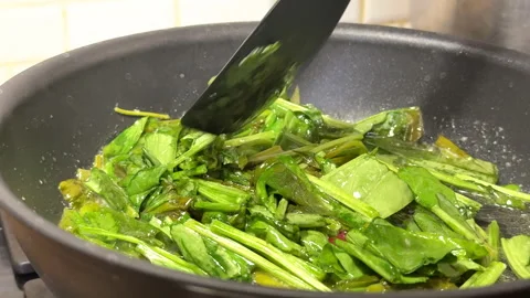 The process of making sorrel sauce, in a skillet on the stove top roast sorrel l Stockbeeldmateriaal 301421686