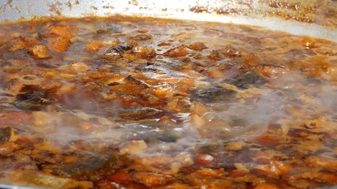 The process of making soup from lamb - shurpa in a cauldron in the open air. Stock Footage 88677015