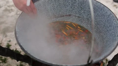 The process of making soup from lamb - shurpa in a cauldron in the open air. Stock Footage 134208311