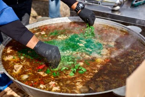 The process of making soup from lamb - shurpa in a cauldron in the open air. Stock Photos