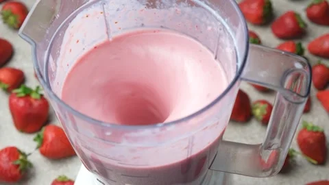 The process of making a strawberry milkshake, whisking all the ingredients in a Stock Footage 311850223