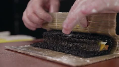 The process of making sushi rolls with dark rice. Chef's hands in transparent Video stock 282431612