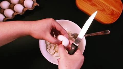 Process of making syrniki. Step 1 - adding egg to cottage cheese. Top view on Stock Footage 309015681