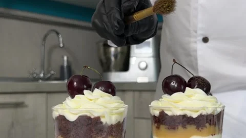 The process of making a trifle cake in transparent cups, creating confectionery Stock Footage 245536975