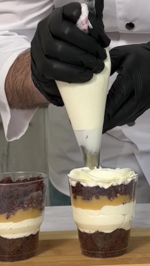 The process of making a trifle cake in transparent cups, creating confectionery Stock Footage 245537219