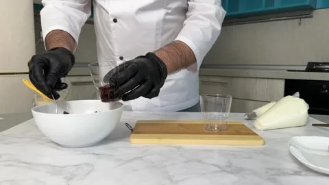 The process of making a trifle cake in transparent cups, creating confectionery Stock Footage 245537334