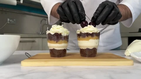 The process of making a trifle cake in transparent cups, creating confectionery Stock Footage 245537429