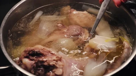 Process of making turkey soup. Boiling broth with turkey legs and vegetables Video stock 323294155