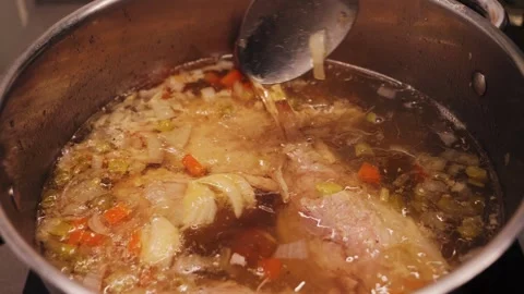Process of making turkey soup. Close-up of boiling broth with turkey feet and Video stock 329996952