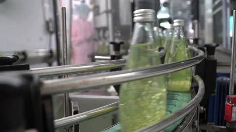 The process of manufacturing line production of juice bottling on conveyor li Stock Footage 142701580