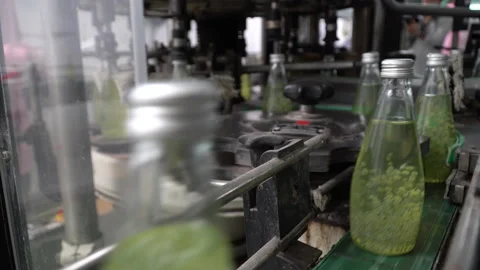 The process of manufacturing line production of juice bottling on conveyor li Stock Footage 142701722