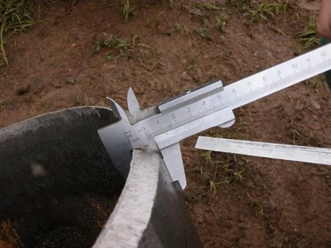 The process of measuring pipe thickness with a caliper. Stock Photos