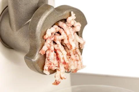 Process of meat grinding in the kitchen with mincing machine, close up Foto stock