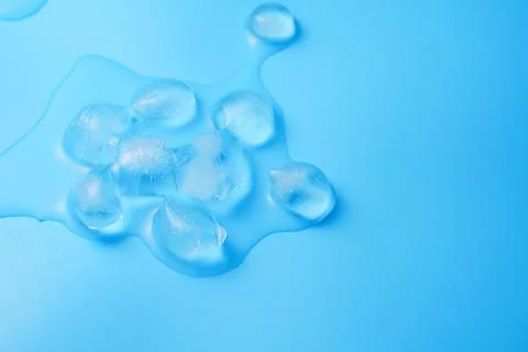 The process of melting ice cubes on a blue Stock Photos